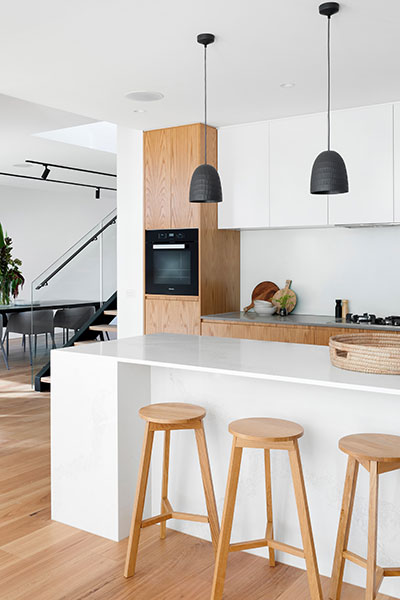 Contemporary open-plan kitchen with pendant lighting designed by The Omega Group