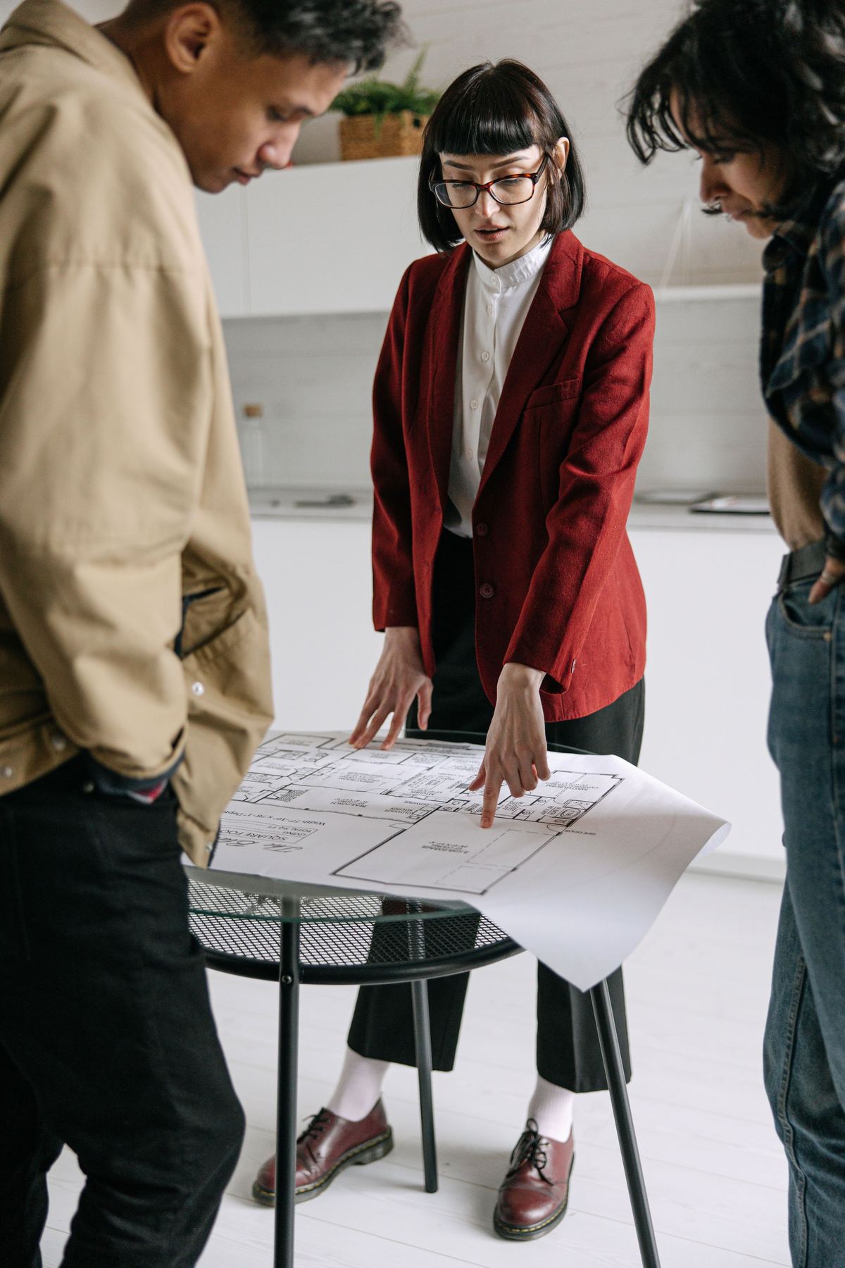 An interior designer reviewing floor plans and a payment schedule with homeowners
