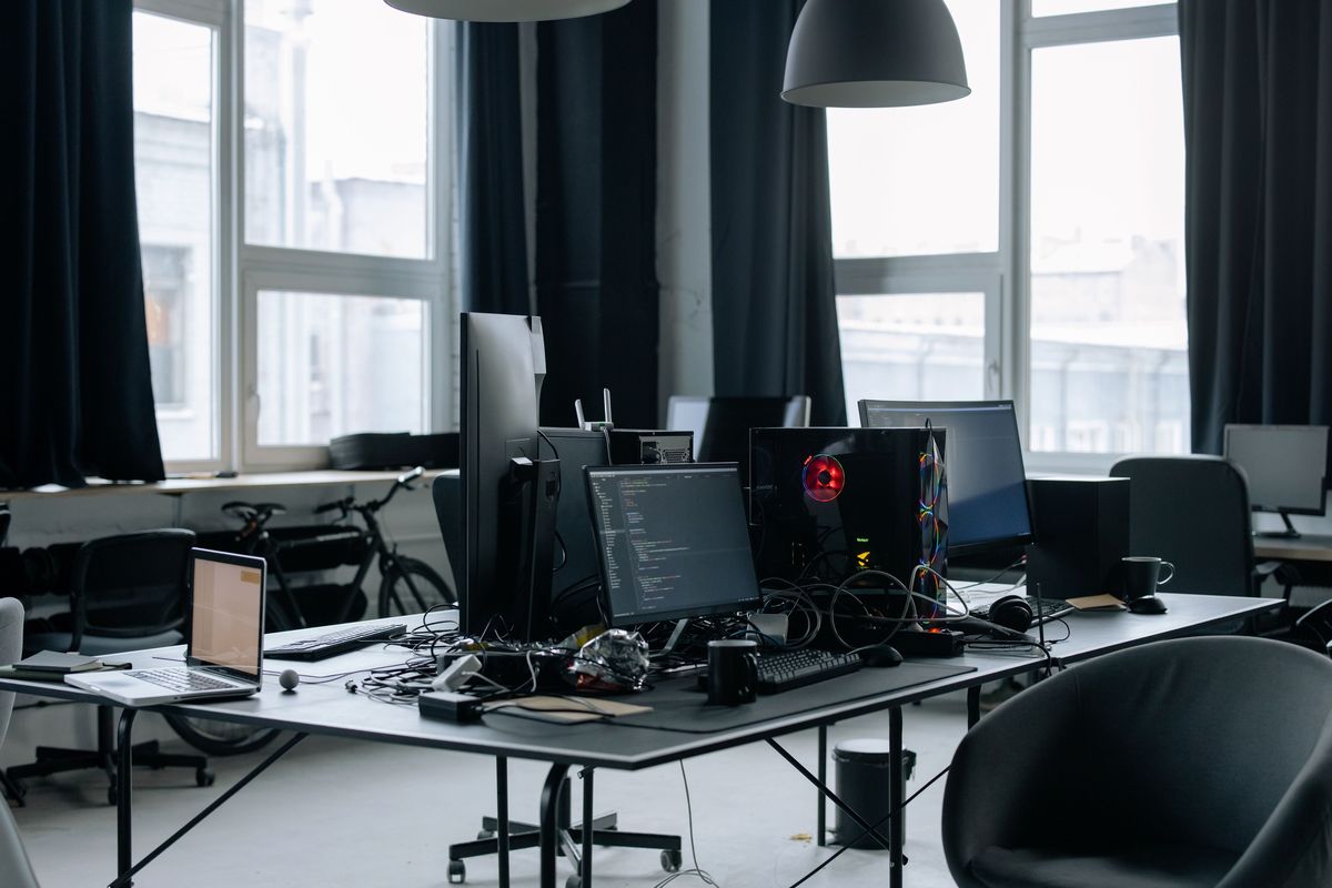 Simple open bench desks with multiple monitors in a small startup office workspace